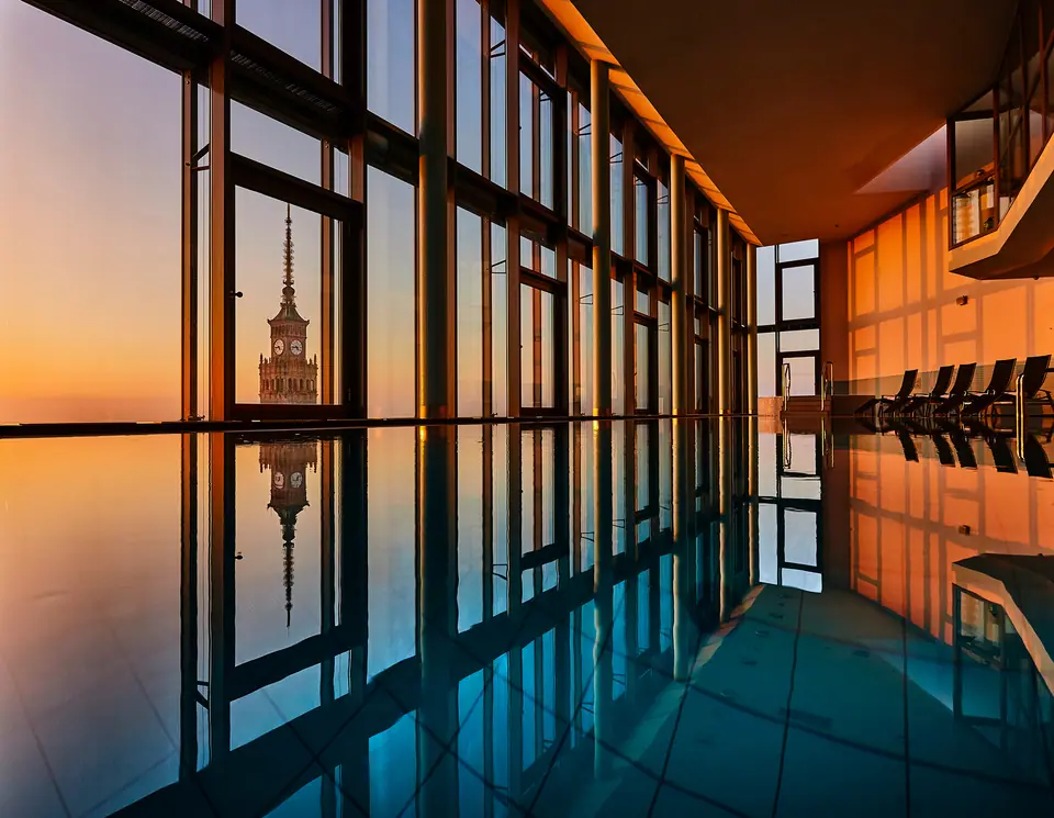 Basen hotelu InterContinental o zachodzie słońca, z widokiem na Warszawę